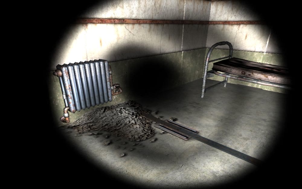 A derelict prison cell lit by a narrow torch beam, showing a rusted radiator and bed frame