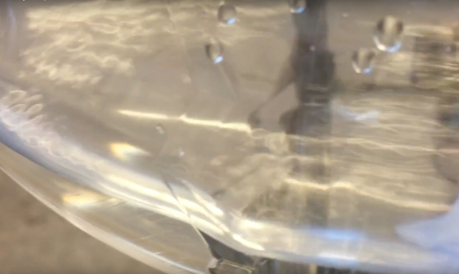 Close view of water rippling inside the agitated bottle